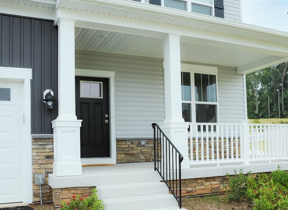 Gray and white home siding with a black front door